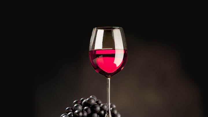 Red Wine With Black Grapes On Wooden Drum